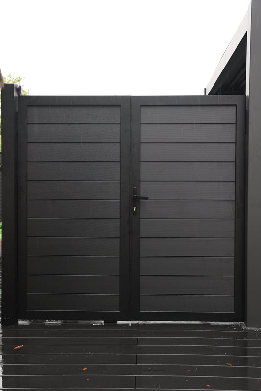 Black aluminum double privacy gate with horizontal slat panels on modern deck