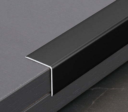 Black aluminum wall panel end cap trim installed on panel edge, providing a clean finished edge and durable protection for modern interior wall panel systems