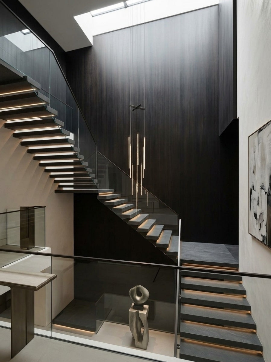 Floor-to-ceiling blackwood veneer wall panels surrounding a modern floating staircase and skylight