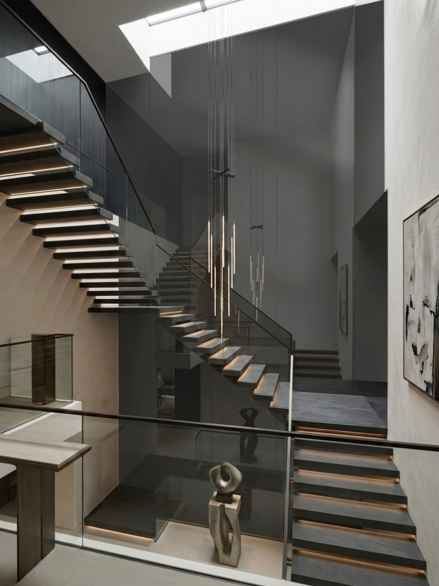 Gray mirror wood veneer panel wall surrounding a modern floating staircase with glass railings