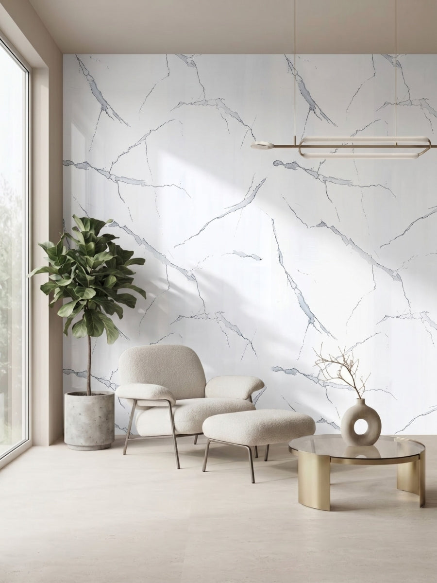 Minimalist sitting area with a White Gray Pearl Marble PVC feature wall, cream chair, ottoman, and potted tree